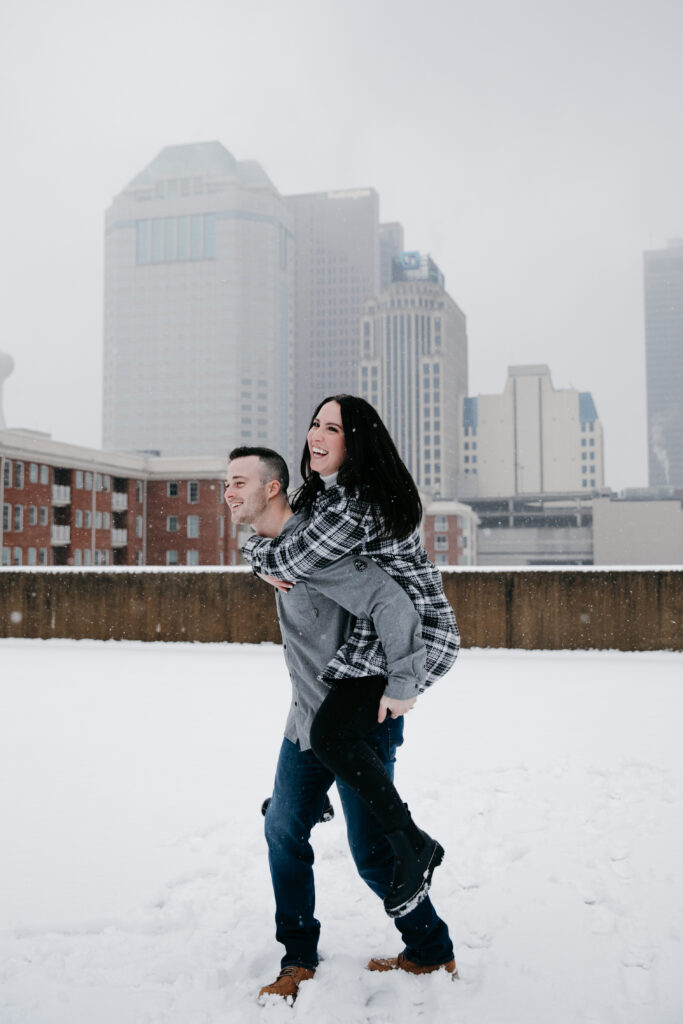 winter engagement couple piggyback ride