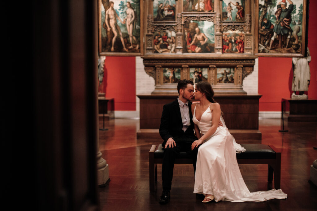 bride and groom sitting on bench in art museum