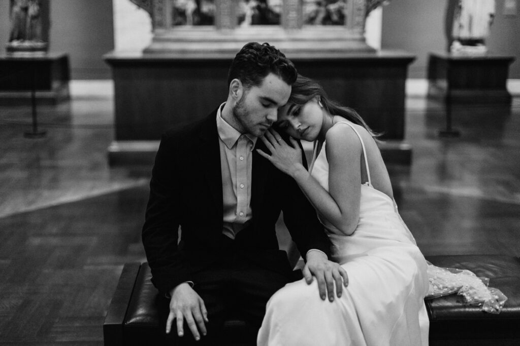 couple embracing on bench in art museum